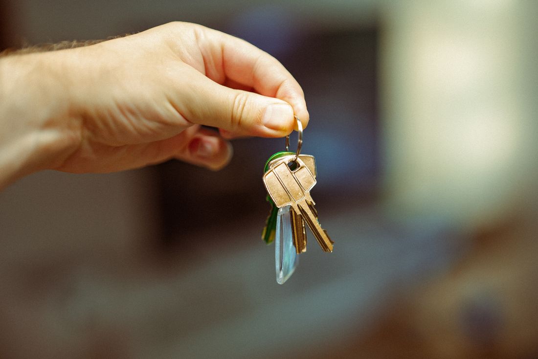 A hand holding a set of house keys
