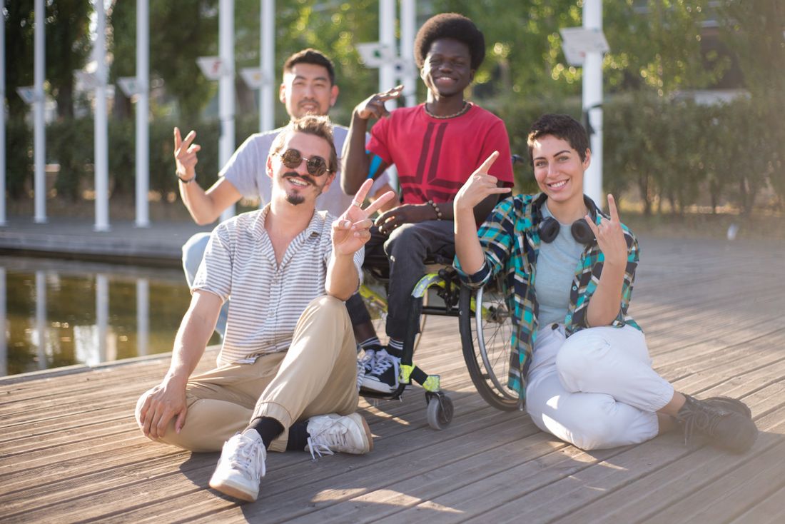 A group of friends outdoors, including a wheelchair user